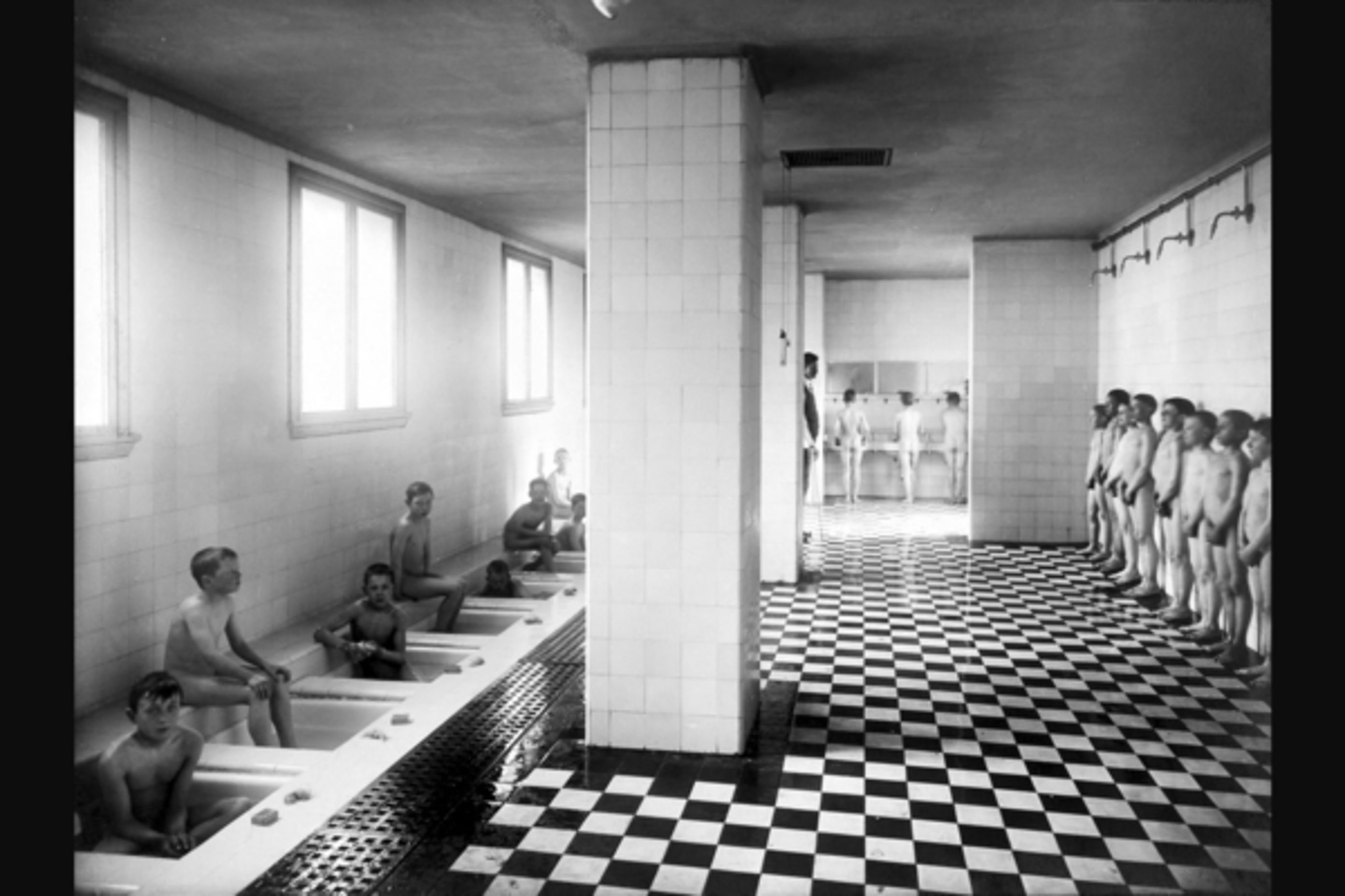 13 Fotograf ukjent, 1922. Byarkitekten. Bildenummer: A-20031/Ua/0003/017. Utlånt av Oslo byarkiv. Bildetekst: Dusj, bad, gutter som bader og dusjer, kroppsvask. Herslebs skole 1922