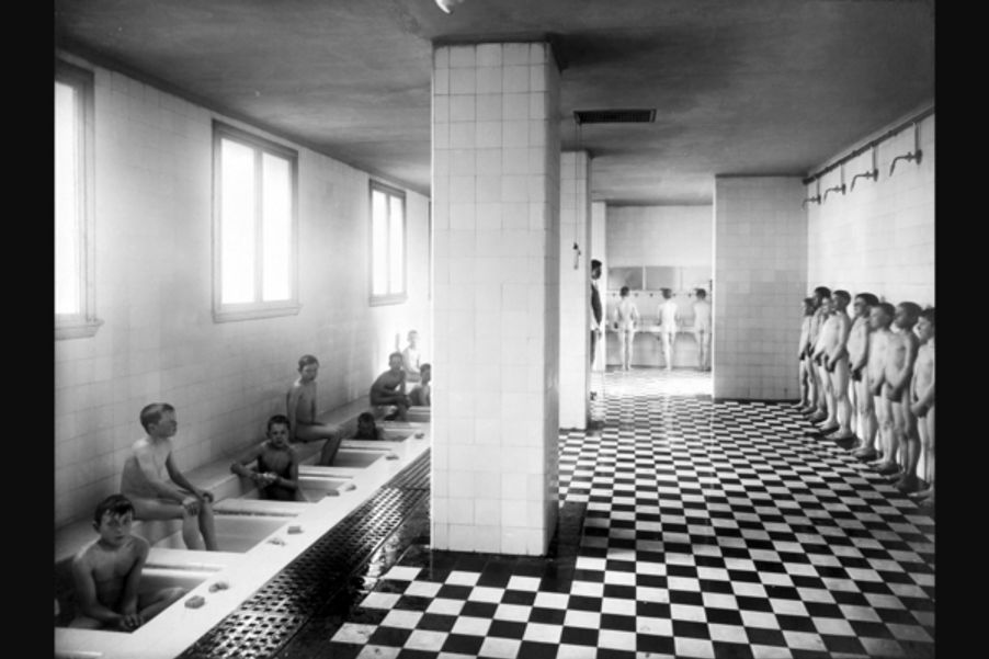 13 Fotograf ukjent, 1922. Byarkitekten. Bildenummer: A-20031/Ua/0003/017. Utlånt av Oslo byarkiv. Bildetekst: Dusj, bad, gutter som bader og dusjer, kroppsvask. Herslebs skole 1922