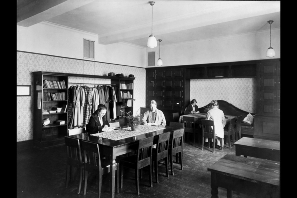 17 Fotograf ukjent, 1922. Byarkitekten. Bildenummer: A-20031/Ua/0003/009. Utlånt av Oslo byarkiv. Bildetekst: Lærerværelse, kvinner ved bord, interiør. Herslebs skole 1922