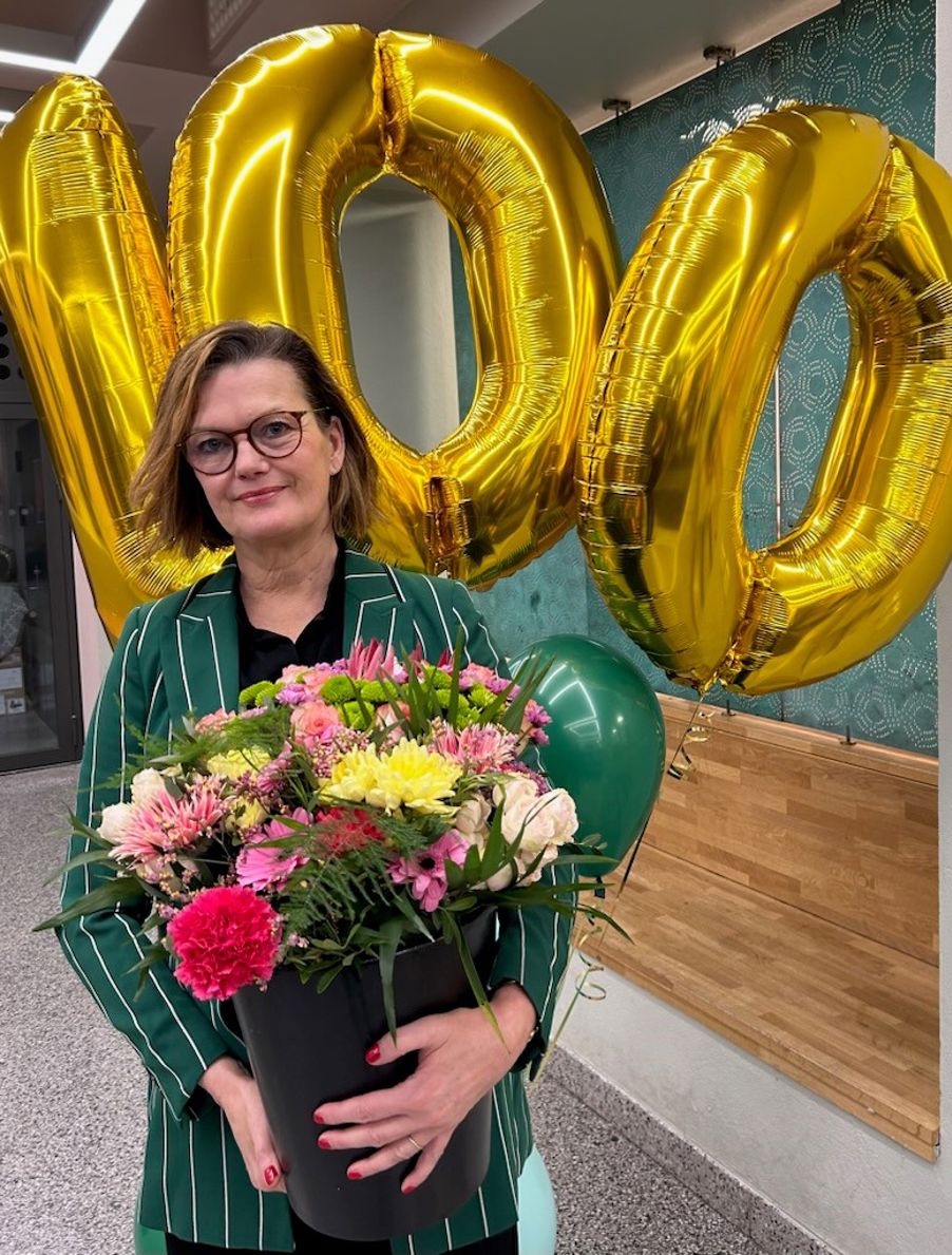 Rektor med blomstergaver gitt til skolen
