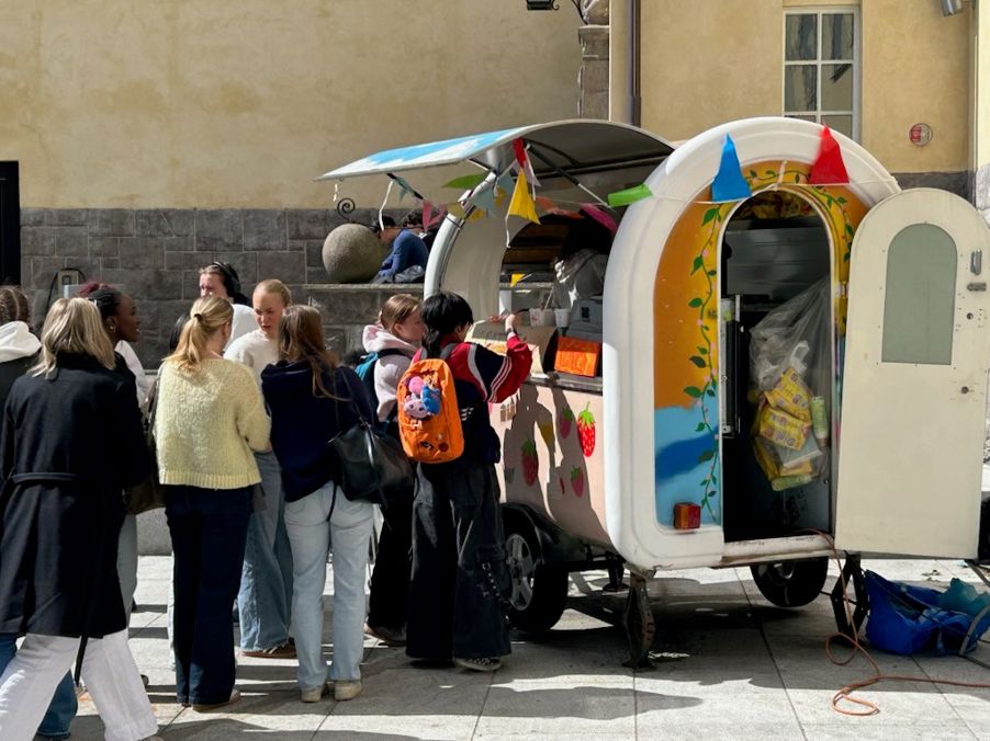 en gruppe mennesker som står rundt en matbil
